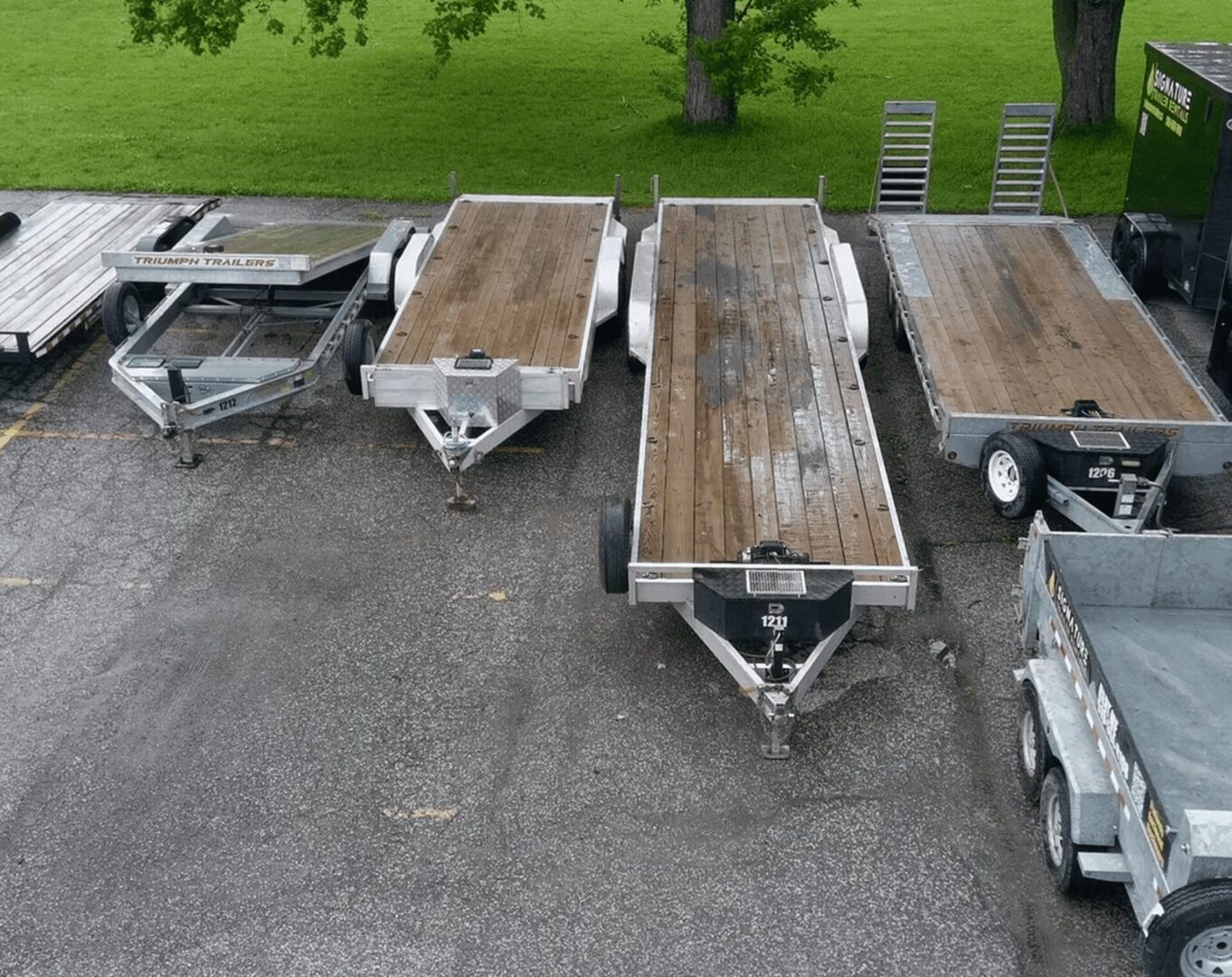 Four flatbed trailers parked in a row.