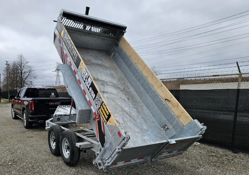 Dump trailer tilted up behind truck.